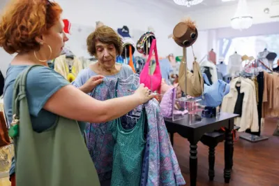 Two women looking at clothing together in a thrift store