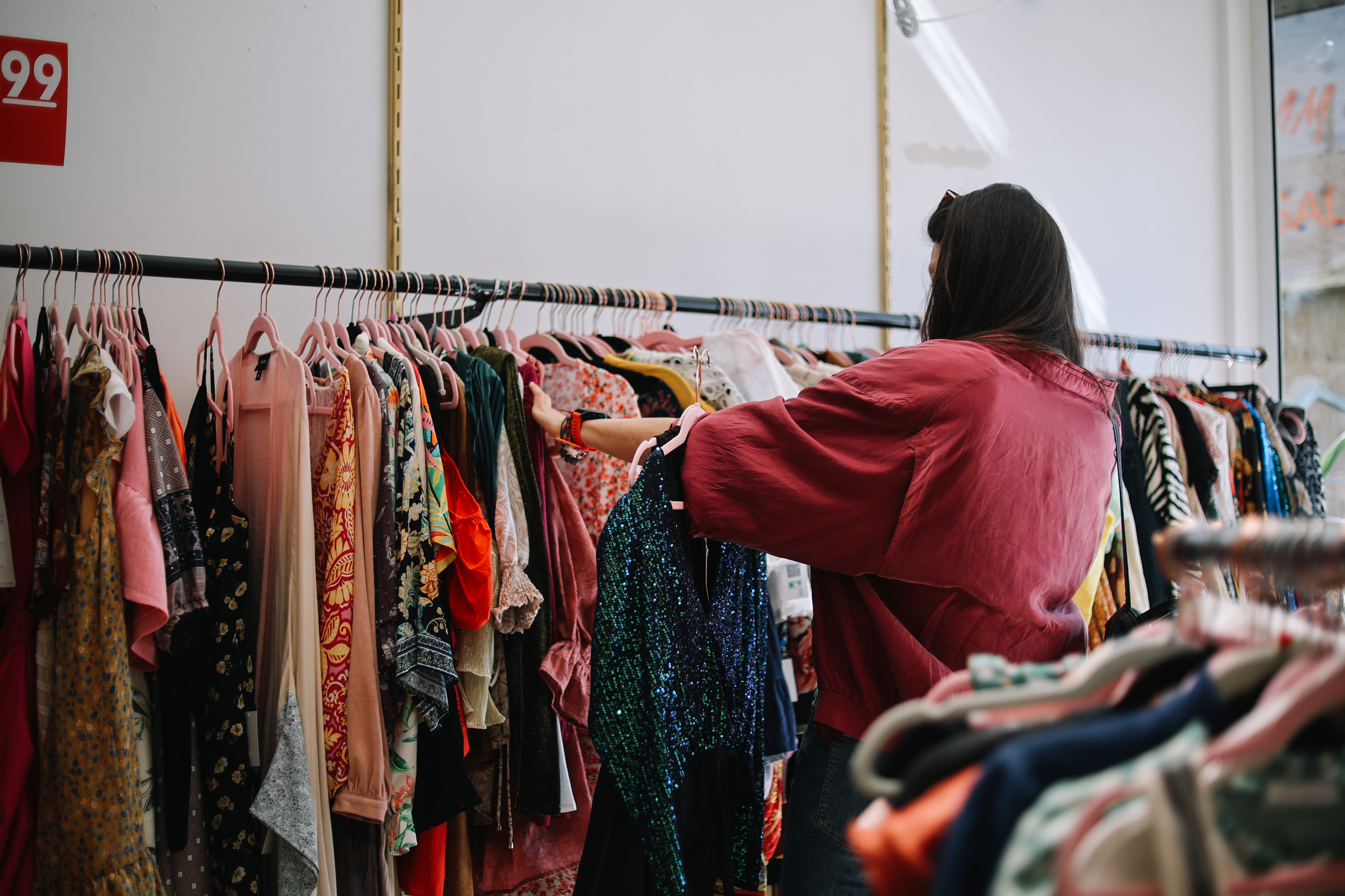 Shopper browsing colorful clothing racks at Sister's Closet